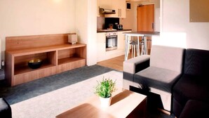 A modern living room with a sofa, a coffee table, and a small plant. - For Students Only Chapter Highbury I in London (London)