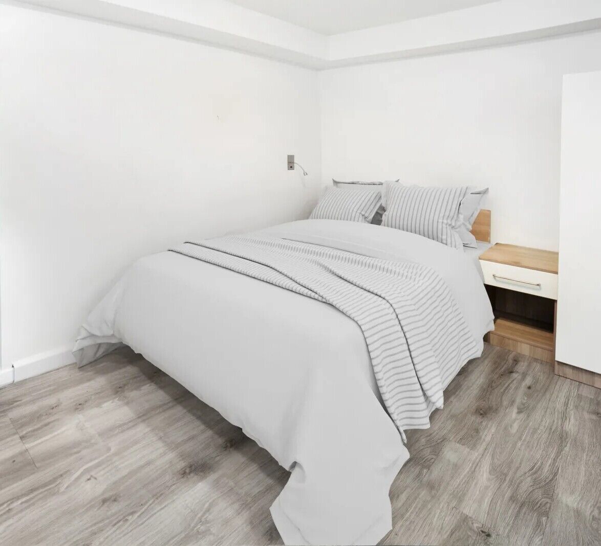Une chambre à coucher avec un lit, une table de chevet et un plancher en bois.