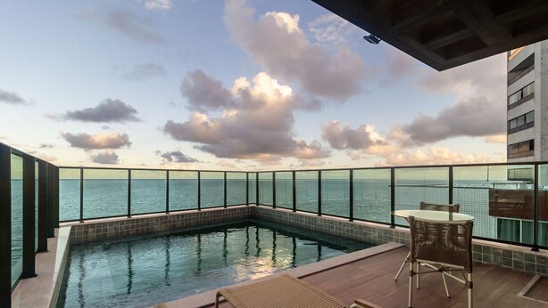 Ein Pool auf dem Dach mit freiem Blick auf das Meer und den Himmel.