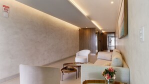 Ein modernes Wohnzimmer mit Sofa, Sessel und Couchtisch.