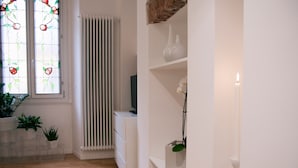 A room with a radiator, white shelving, and potted plants. - Italianway - Copernico I (Milan)