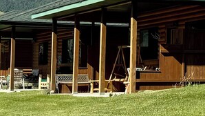 A wooden lodge with a covered porch and a view of snow-capped mountains. - 
Charming Riverside Cabin on Yellowstone River - 2 Bedrooms & 2 Bathrooms, Relax (Gardiner)
