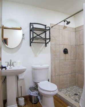 A bathroom with a sink, toilet, and shower. - Waterfront Sky Cabin 2 by Best Texas Travel (New Braunfels)