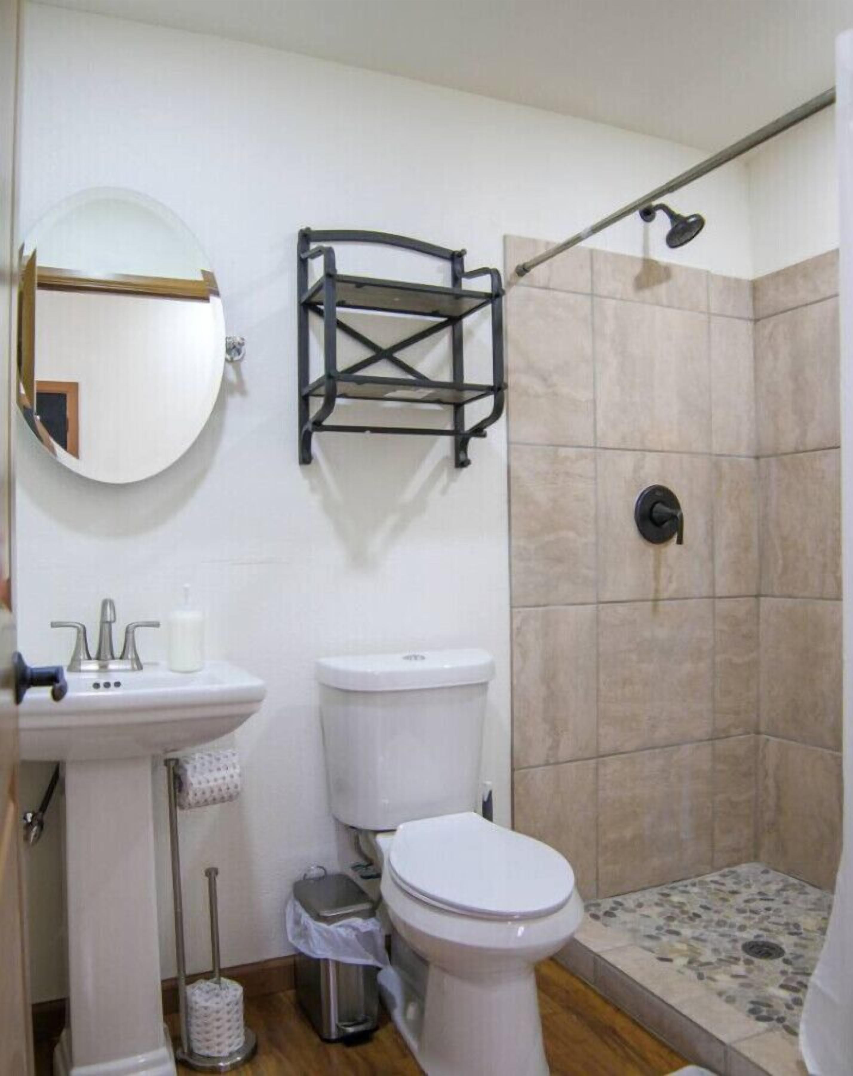 A bathroom with a sink, toilet, and shower.