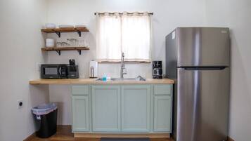 Fridge, microwave, coffee/tea maker, cookware/dishes/utensils
