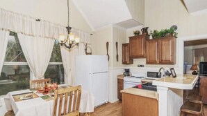 A kitchen with wooden cabinets, a refrigerator, a stove, and a sink. - Treehouse  2 - Cardinal Casita by Best Texas Travel (New Braunfels)