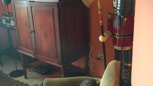 Una habitación con un armario de madera, una silla y un objeto decorativo que se asemeja al casco de un soldado con una bandera.