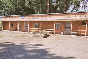 Simple, single-story motel with a flat roof and a front porch area.