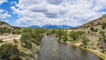 Une rivière qui traverse une vallée, avec des montagnes en arrière-plan.