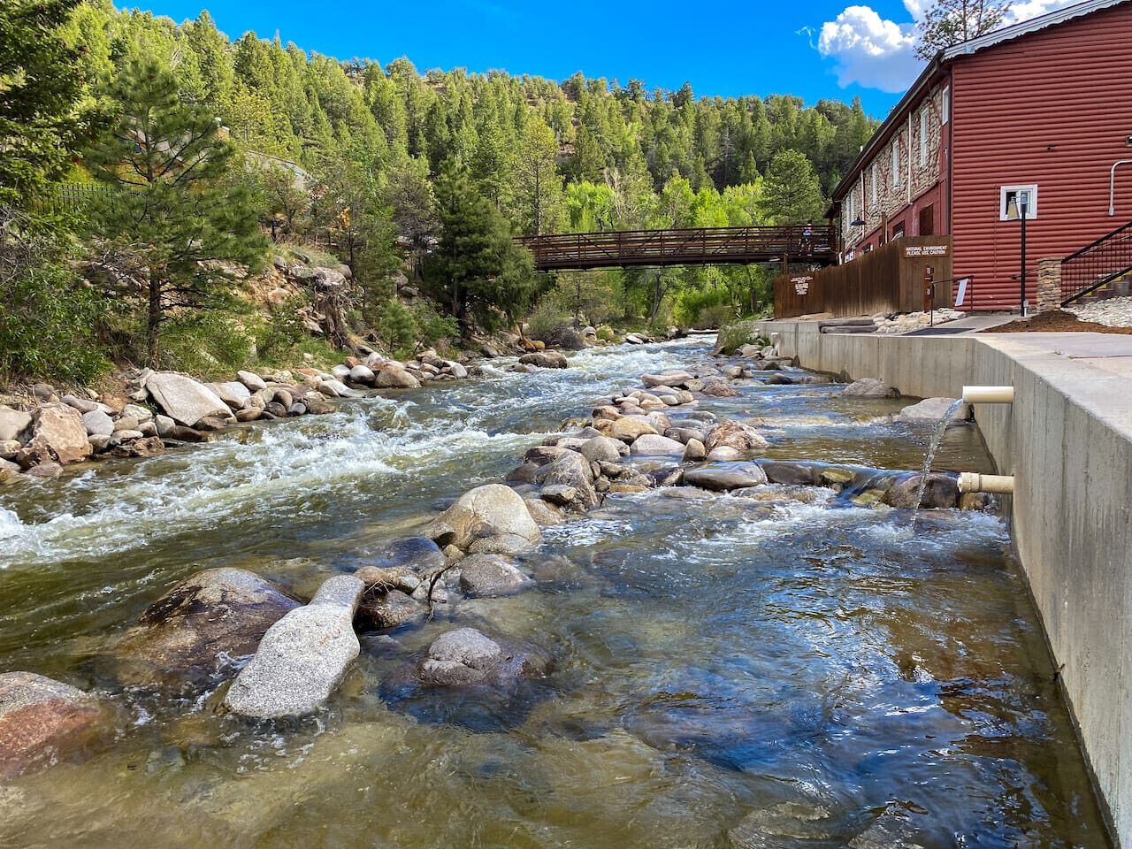 A river with rocks and a wooden bridge.