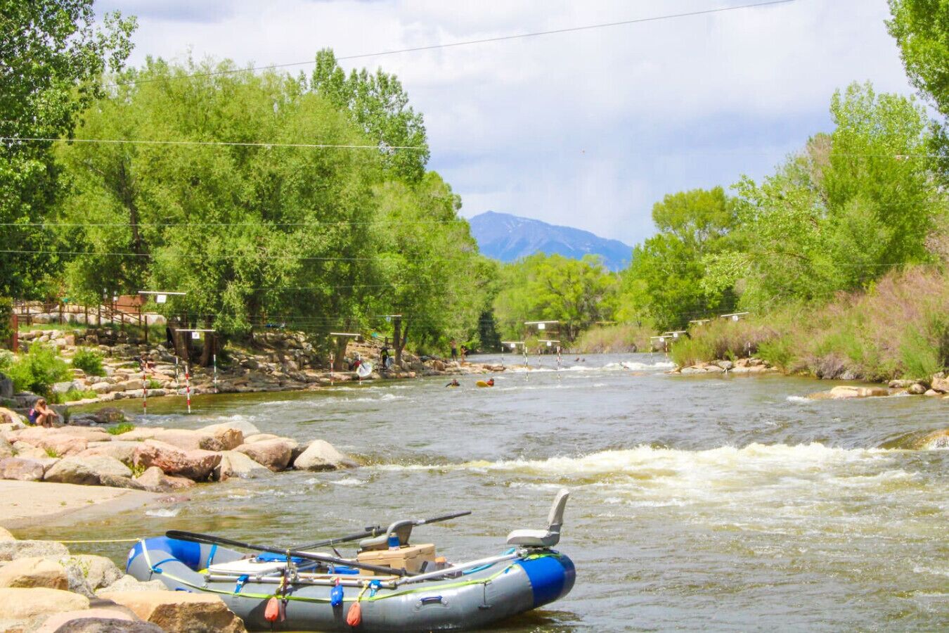Une rivière avec un radeau, des rochers et des arbres.