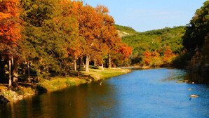 A river surrounded by trees with autumn foliage. - Treehouse 5 - Robins Roost by Best Texas Travel (New Braunfels)