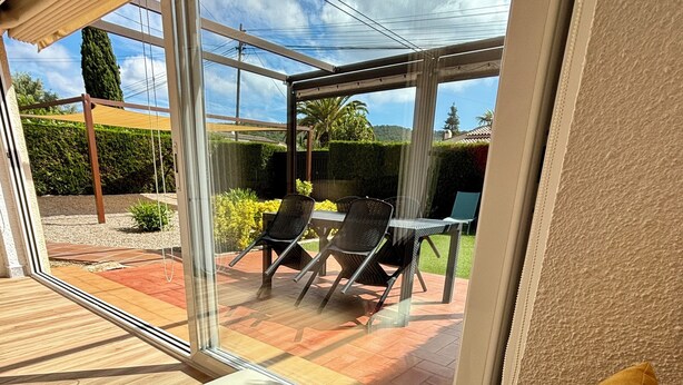 A modern room with a large sliding glass door leading to an outdoor patio area.