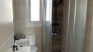 Een haardroger, handdoeken, zeep, toiletpapier