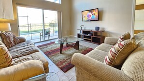 A living room with a large window, a flat-screen TV, and a glass coffee table. - 4 Bedroom and 3 Bath Home in the Highly Rated Community of Solana! (Davenport)