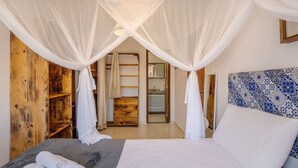 A bedroom with a canopy bed, wooden wardrobe, and a bathroom visible through an open door. - PPRAs Casas ao lado da praia Barramares (Ilhéus)