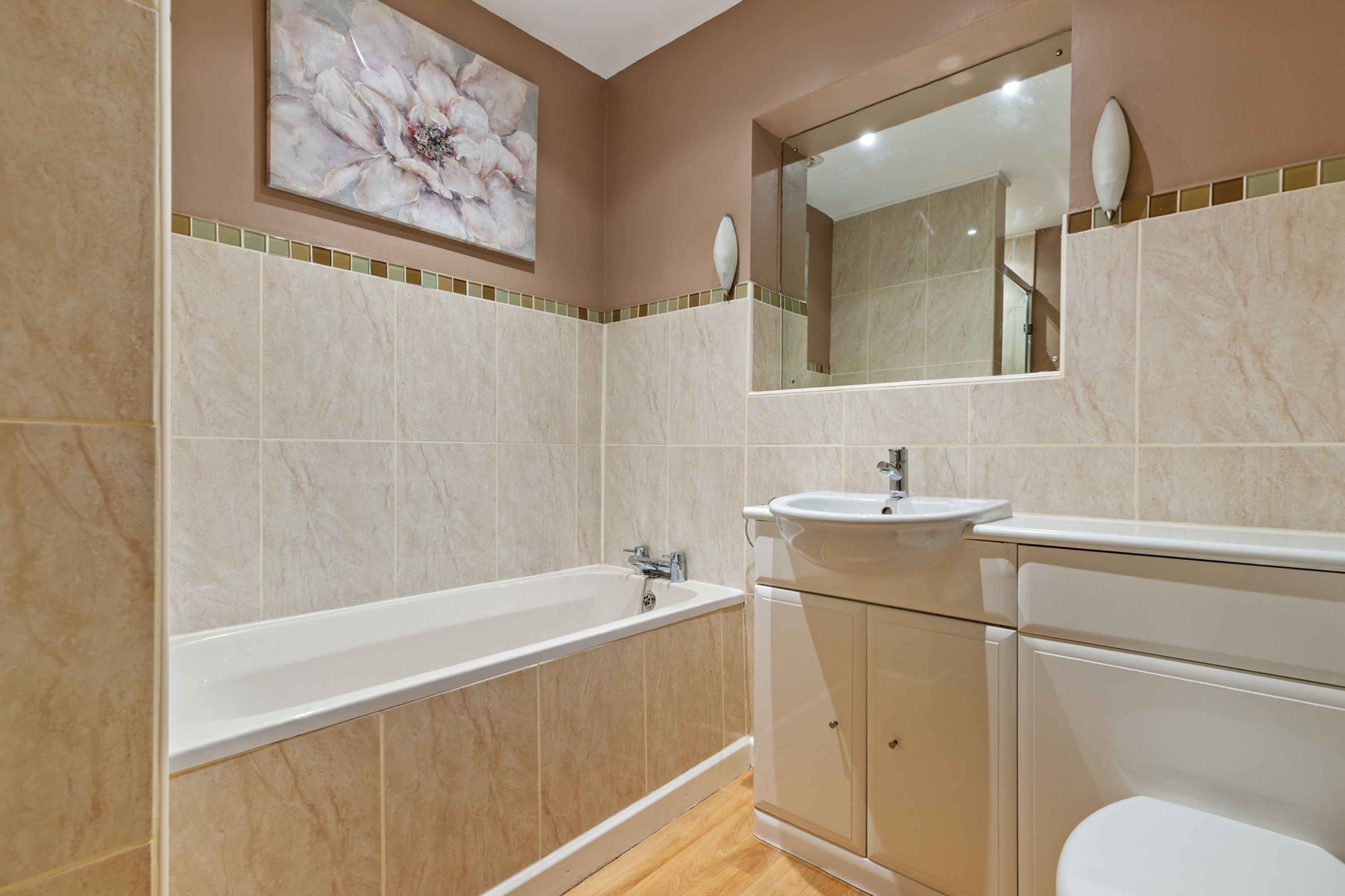 A modern bathroom with a bathtub, sink, and toilet.