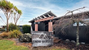 Un panneau en bois portant l’inscription « SNOW-VANNAH » et un logo représentant une montagne, indiquant la présence d’une station de ski ou d’un chalet de montagne.