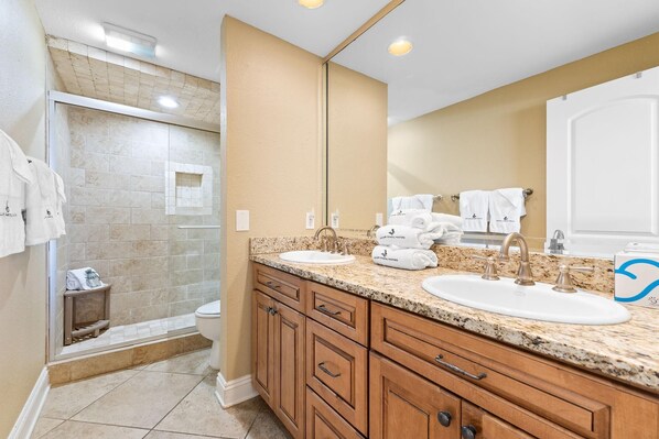 A bathroom with two sinks, a shower, and a large mirror. - Shipwatch A301 (Pensacola)