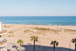 A beach with a lifeguard tower, palm trees, and a clear view of the ocean.