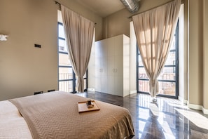 Une chambre d’hôtel avec un grand lit, une armoire et une vue par la fenêtre.