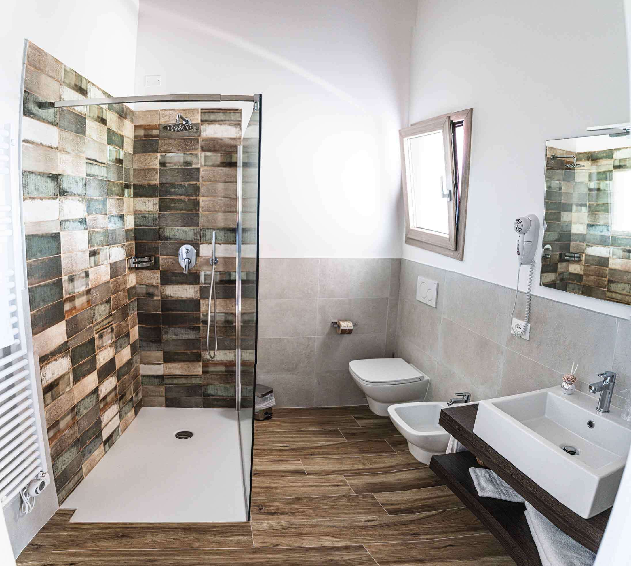Une salle de bain équipée d’une douche, de toilettes, d’un bidet et d’un lavabo.
