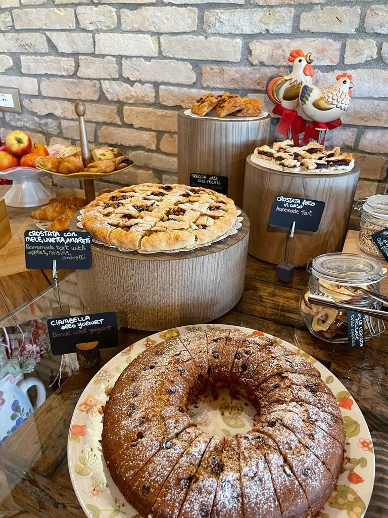Una vitrina de pastelería con diversos productos horneados y un pastel.