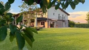 A two-story house with a balcony, a lawn, and a garden. - Agriturismo Casale ai Prati (Latisana)