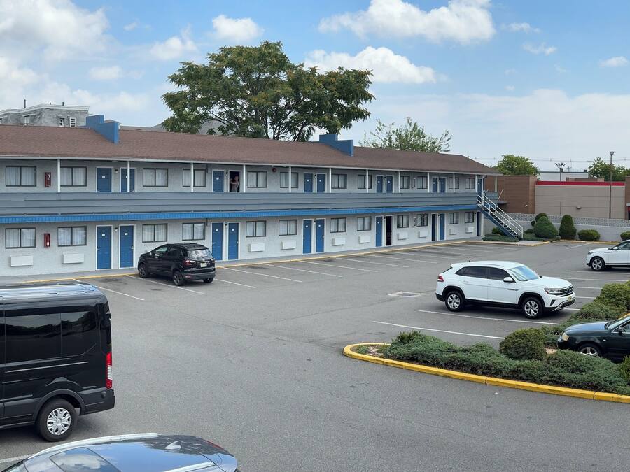Un motel con varias habitaciones, un estacionamiento y un Burger King al otro lado de la calle.