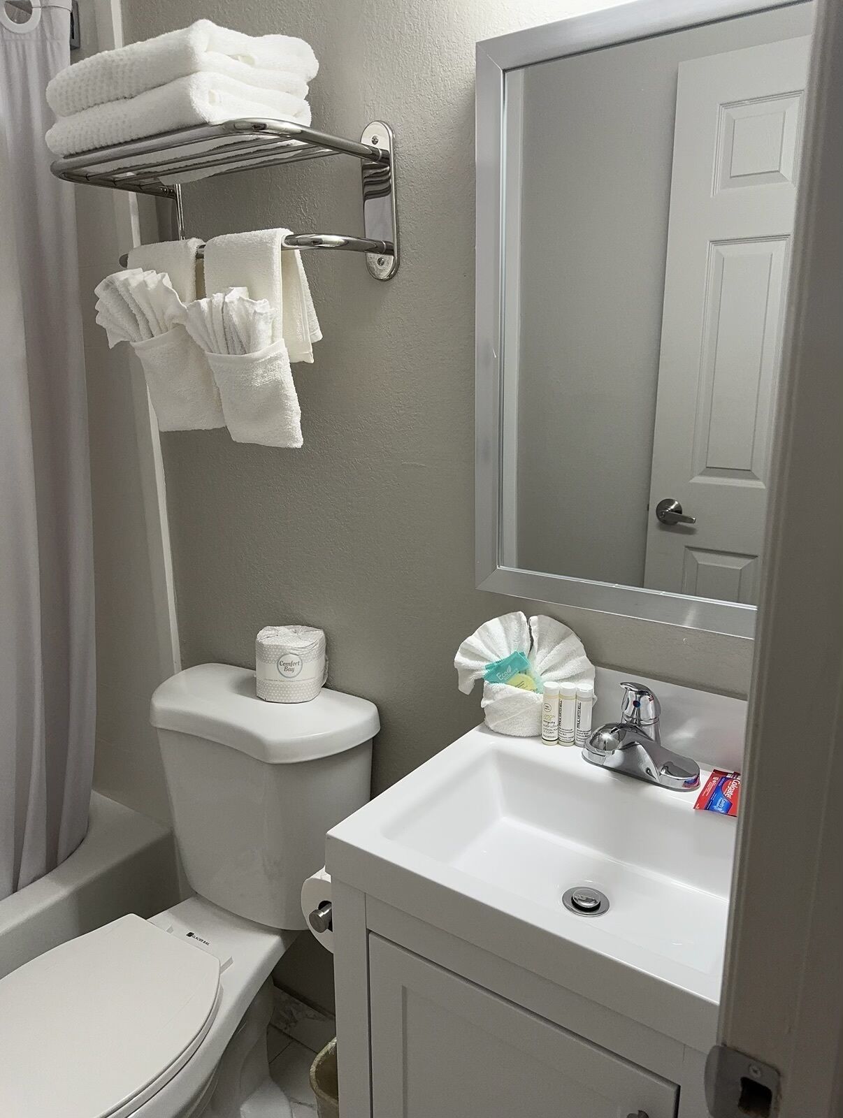 A bathroom with a toilet, sink, and towel rack.