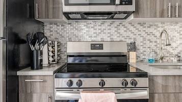 A modern kitchen with a built-in microwave, oven, and stovetop.