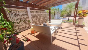 A covered outdoor seating area with wicker furniture and a decorative wooden pergola. - JARDINS DO ATLANTICO by Penareia.tur.br (João Pessoa)