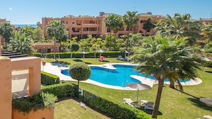 Ein Resort mit Schwimmbad, Palmen und Blick auf den Ozean.