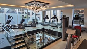 A modern gym with treadmills, exercise bikes, and a weight machine.