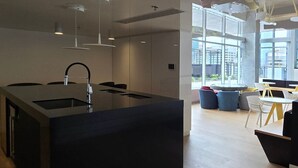 A modern kitchen with a central island, a built-in sink, and pendant lighting.