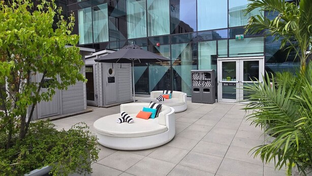 A modern outdoor seating area with a glass building in the background.