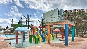 A colorful playground with a water feature and palm trees. - The Caravelle Resort (Myrtle Beach)