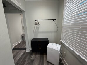 Une petite salle de bain avec des toilettes blanches, un meuble de rangement noir et un radiateur blanc.