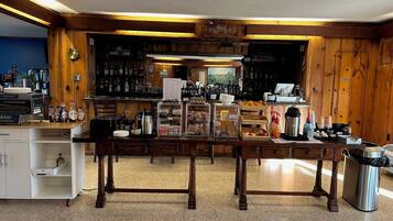 A bar area with wooden paneling, a counter with various items, and a visible menu board.