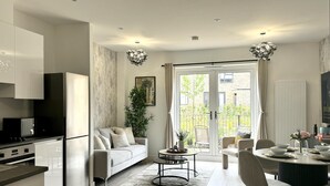 A modern kitchen with a dining area, a sofa, and a view of the outside. - Apricot House- Cozy 2 Bedroom House in Birmingham (Birmingham)