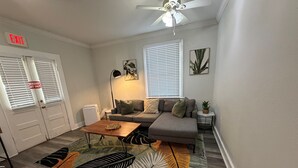 Una sala de estar con sofá, mesa de centro y ventilador de techo.