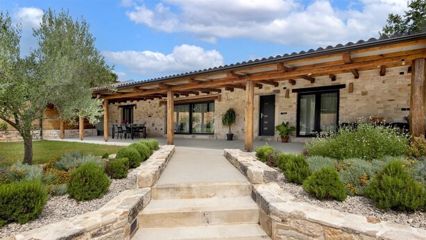 A stone building with a covered patio, steps leading to the entrance, and a garden with various plants. - LA GRONDA Holiday House (Rovinj)