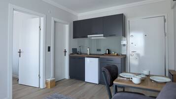 Standard Apartment | Private kitchen | Mini-fridge, stovetop, cookware/dishes/utensils, dining tables