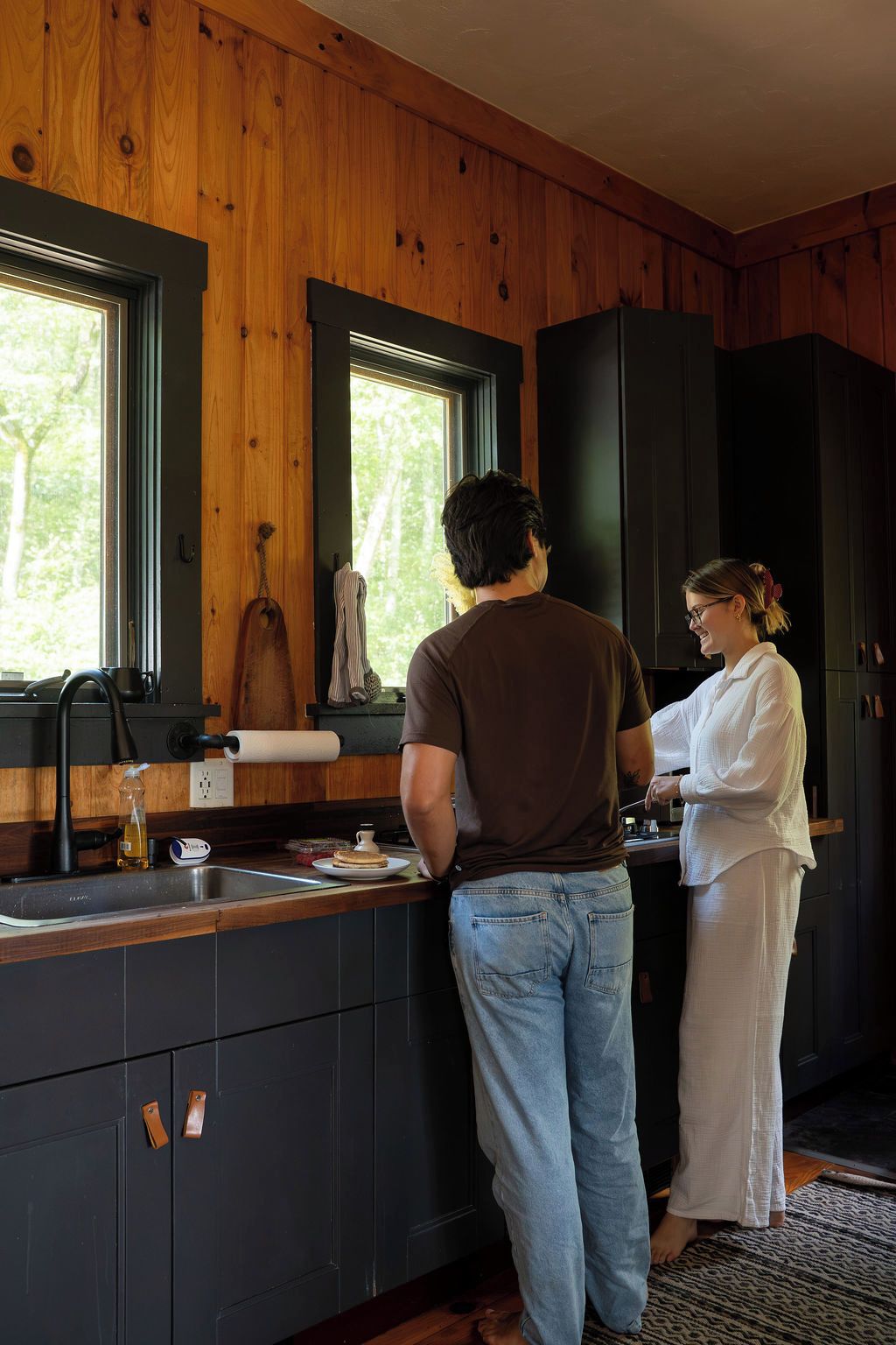 A kitchen with wooden cabinets, a sink, and a window.