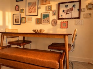Un coin repas avec une table en bois, deux chaises rembourrées et un bol décoratif.