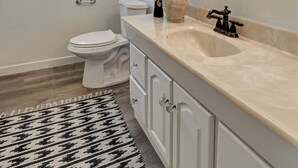 Une salle de bain avec des toilettes, un lavabo, un miroir et une fenêtre.