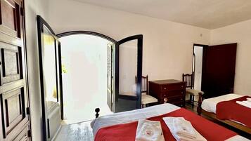 Een hotelkamer met twee bedden, een bureau en een stoel.