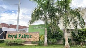 Une enseigne pour le Royal Palms, avec un mur en briques et de la verdure.