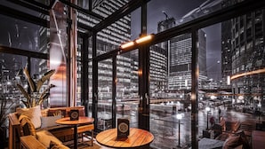 Un interior moderno con un ventanal grande que da a una vista nocturna de la ciudad.
