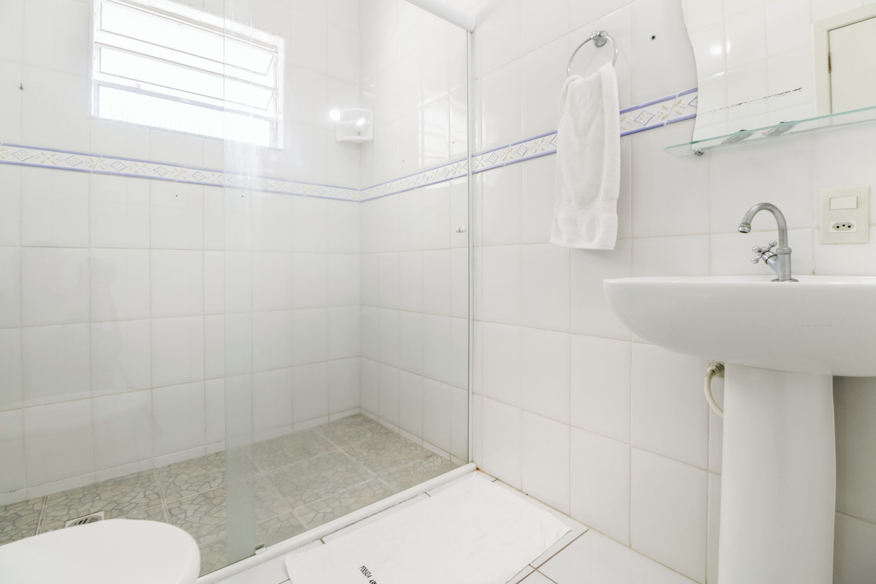 Een badkamer met douche, toilet en wastafel.